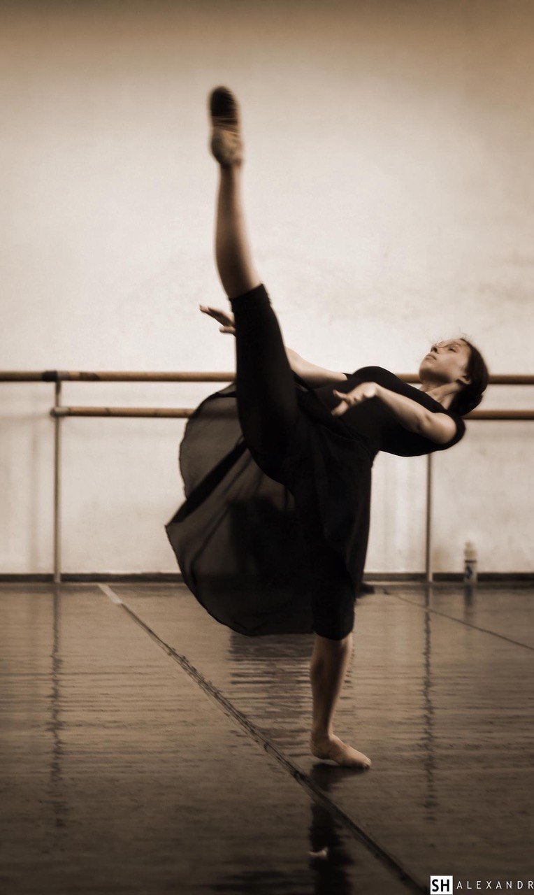 A ballet dancer rehearsing at the barre in a studio